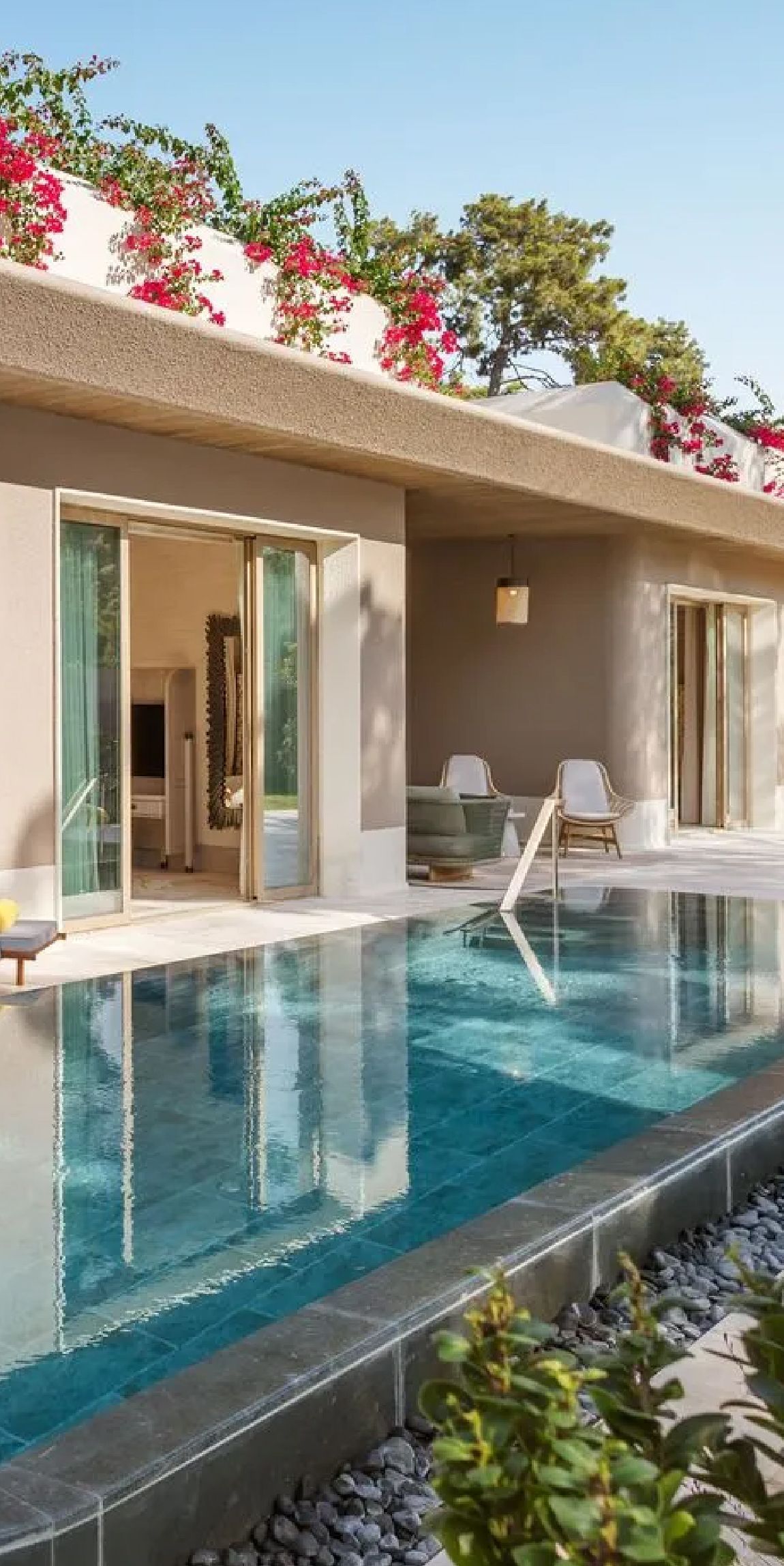 A house with a large swimming pool in front of it.