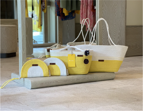 Three yellow and white baskets are sitting on a shelf in a store.